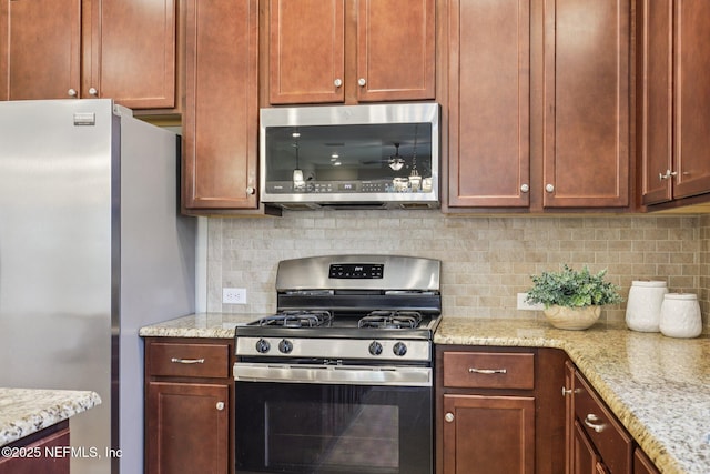 48 Gilchrist Way, Saint Johns, FL 32092 - kitchen featuring appliances with stainless steel finishes, tasteful backsplash, and light stone countertops