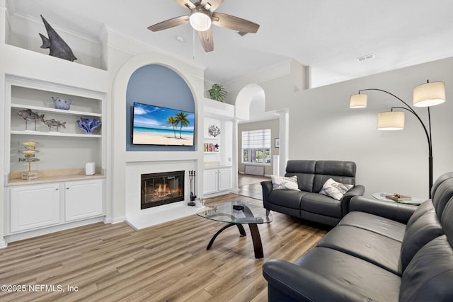 8523 Hampton Landing Dr, Jacksonville, FL 32256 - living area featuring decorative columns, ornamental molding, built in shelves, a ceiling fan, and a glass covered fireplace