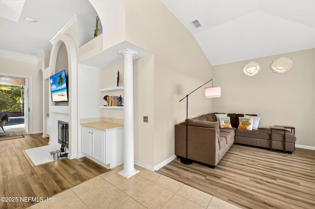 8523 Hampton Landing Dr, Jacksonville, FL 32256 - living room featuring decorative columns, a fireplace, vaulted ceiling, light wood-style flooring, and ornamental molding