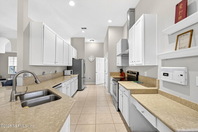 8523 Hampton Landing Dr, Jacksonville, FL 32256 - kitchen featuring stainless steel appliances, light countertops, white cabinets, light tile patterned flooring, and recessed lighting