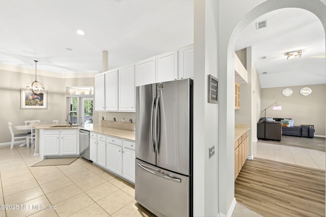 8523 Hampton Landing Dr, Jacksonville, FL 32256 - kitchen with stainless steel appliances, a peninsula, light countertops, light tile patterned flooring, and white cabinets