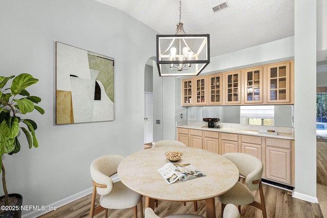 8523 Hampton Landing Dr, Jacksonville, FL 32256 - dining space featuring a chandelier, dark wood-style floors, arched walkways, and vaulted ceiling