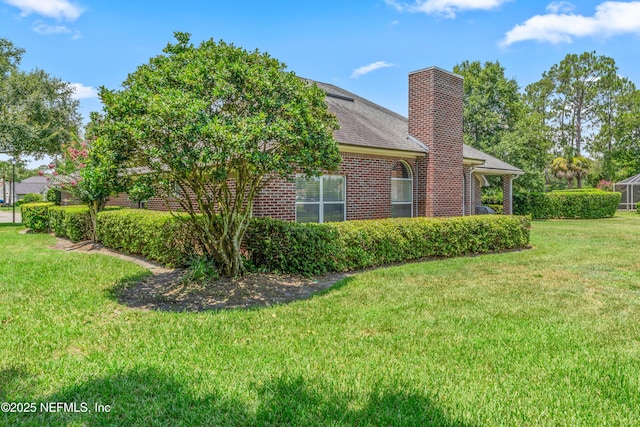 13707 Alesbury Ct, Jacksonville, FL 32224 - view of home's exterior with brick siding, a yard, a chimney, and roof with shingles