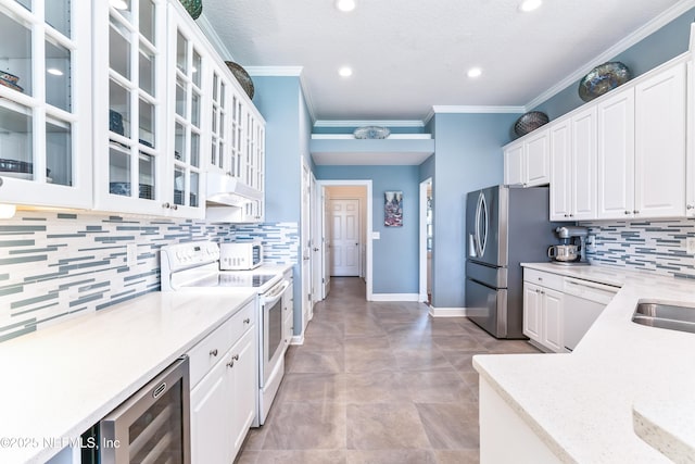 13707 Alesbury Ct, Jacksonville, FL 32224 - kitchen featuring white appliances, under cabinet range hood, wine cooler, white cabinetry, and crown molding