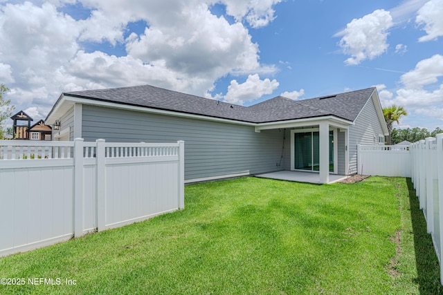 575 Buttonwood Loop, Yulee, FL 32097 - back of property featuring a fenced backyard, a patio area, and a shingled roof