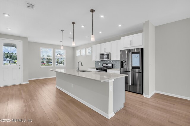 575 Buttonwood Loop, Yulee, FL 32097 - kitchen with appliances with stainless steel finishes, light wood finished floors, white cabinets, an island with sink, and recessed lighting
