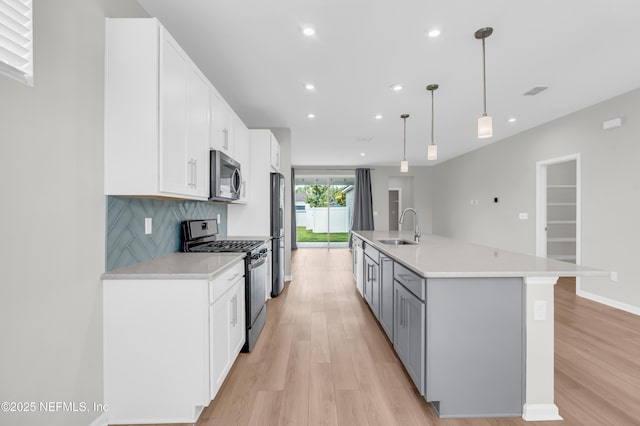 575 Buttonwood Loop, Yulee, FL 32097 - kitchen featuring appliances with stainless steel finishes, light wood-type flooring, light countertops, white cabinets, and recessed lighting