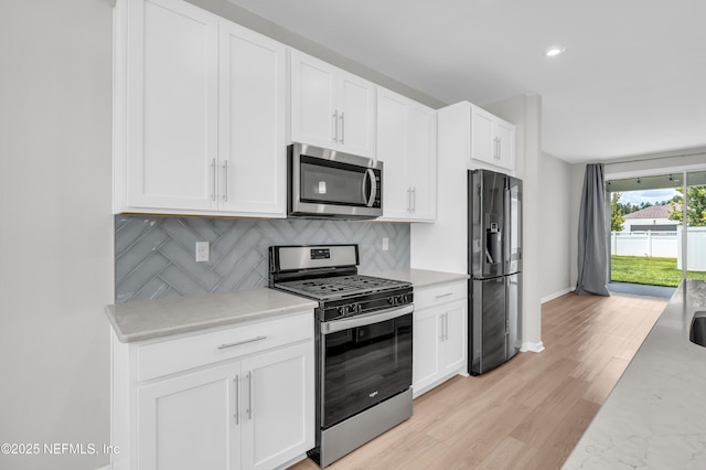 575 Buttonwood Loop, Yulee, FL 32097 - kitchen featuring stainless steel appliances, decorative backsplash, white cabinetry, and light wood-style floors