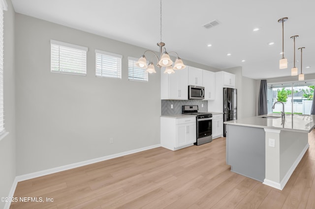 575 Buttonwood Loop, Yulee, FL 32097 - kitchen featuring stainless steel appliances, light wood-style flooring, a chandelier, backsplash, and recessed lighting
