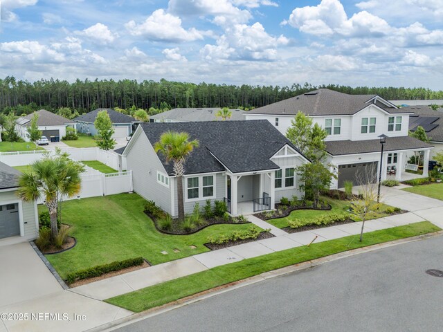 575 Buttonwood Loop, Yulee, FL 32097 - view of front facade featuring driveway, a residential view, roof with shingles, a garage, and a porch