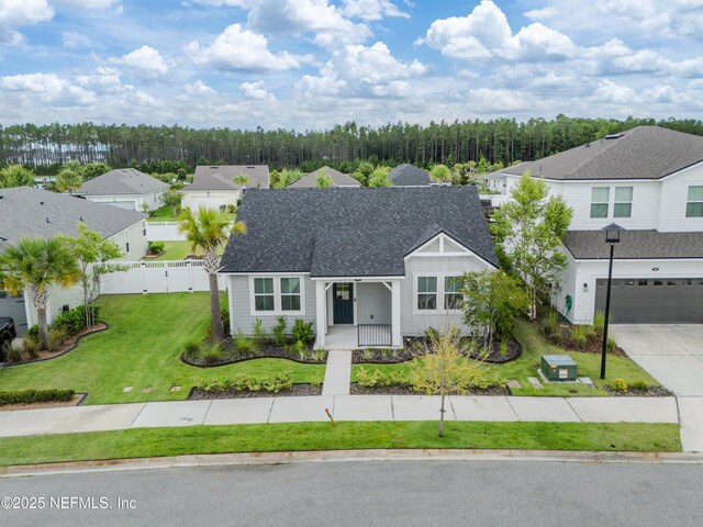 575 Buttonwood Loop, Yulee, FL 32097 - view of front of property with a porch, a garage, driveway, a shingled roof, and a residential view