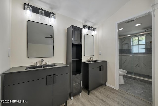 7728 Lynchburg Ct W, Jacksonville, FL 32277 - full bathroom featuring a stall shower, two vanities, wood finished floors, and recessed lighting