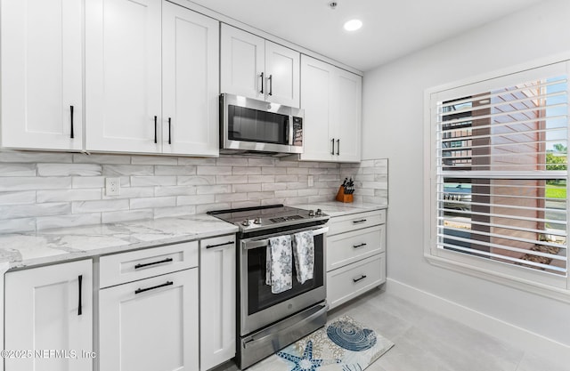 212 16th St Unit A, Saint Augustine Beach, FL 32080 - kitchen featuring appliances with stainless steel finishes, tasteful backsplash, light stone counters, white cabinets, and recessed lighting