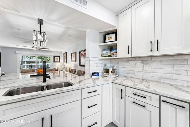 212 16th St Unit A, Saint Augustine Beach, FL 32080 - kitchen with decorative backsplash, white cabinets, open shelves, open floor plan, and light stone counters