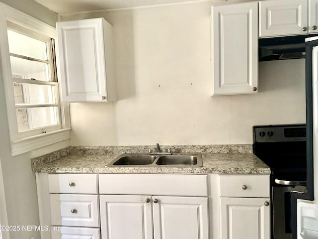 8953 Adams Ave, Jacksonville, FL 32208 - kitchen featuring electric range, white cabinets, light countertops, and under cabinet range hood
