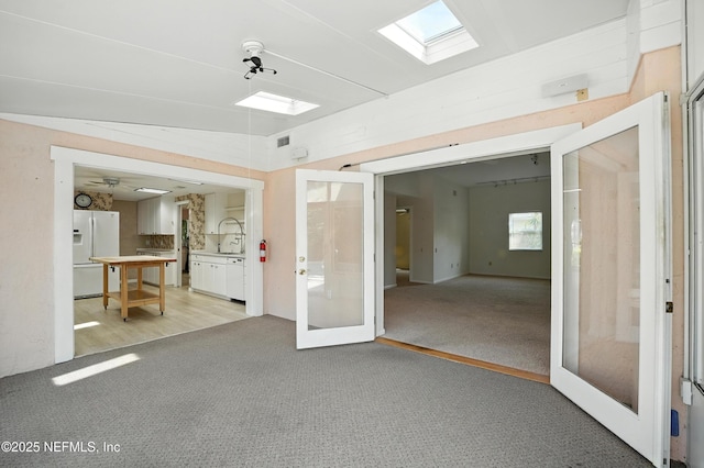 275 Nautical Blvd S, Atlantic Beach, FL 32233 - unfurnished room with light carpet, french doors, and a skylight