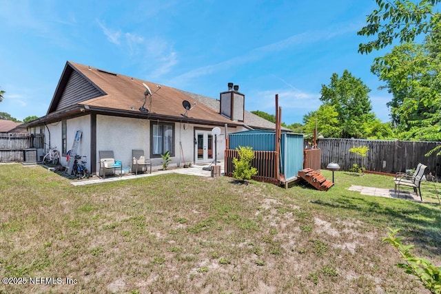 2120 Derringer Cir W, Jacksonville, FL 32225 - back of house featuring french doors, stucco siding, a fenced backyard, a patio, and a chimney