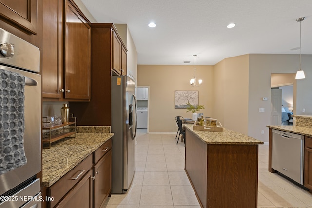 1100 Ashfield Way, Saint Johns, FL 32259 - kitchen with appliances with stainless steel finishes, a kitchen island, washer / clothes dryer, light tile patterned flooring, and recessed lighting