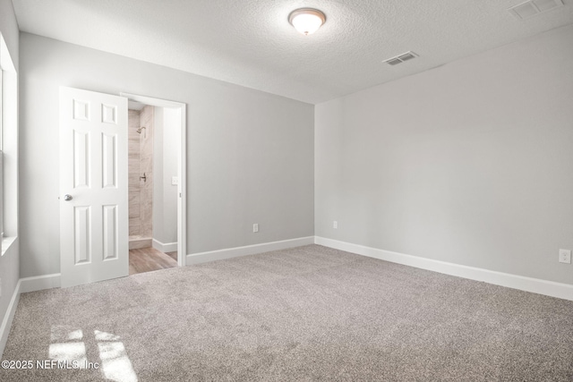 1588 W 15th St, Jacksonville, FL 32209 - unfurnished bedroom featuring carpet floors, a textured ceiling, and connected bathroom
