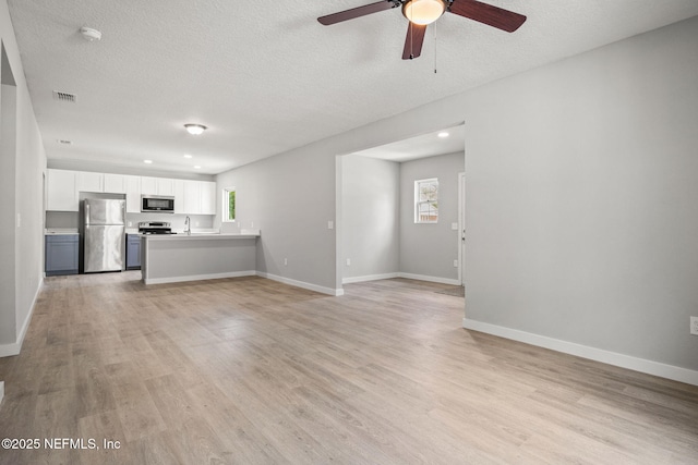 1588 W 15th St, Jacksonville, FL 32209 - unfurnished living room featuring ceiling fan, light wood-style floors, a textured ceiling, and recessed lighting