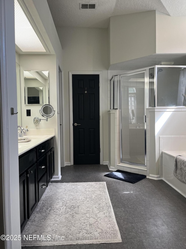 2506 Willow Creek Dr, Fleming Island, FL 32003 - bathroom featuring vanity, a shower stall, a bath, and a textured ceiling