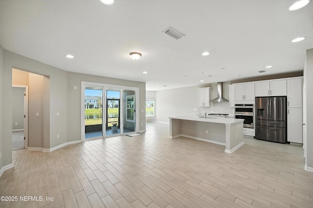 63 Goldcrest Way, Saint Augustine, FL 32092 - kitchen with stainless steel appliances, wall chimney exhaust hood, light countertops, open floor plan, and recessed lighting