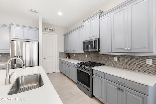 147 Rawlings Dr, Saint Johns, FL 32259 - kitchen with appliances with stainless steel finishes, gray cabinets, decorative backsplash, light countertops, and recessed lighting