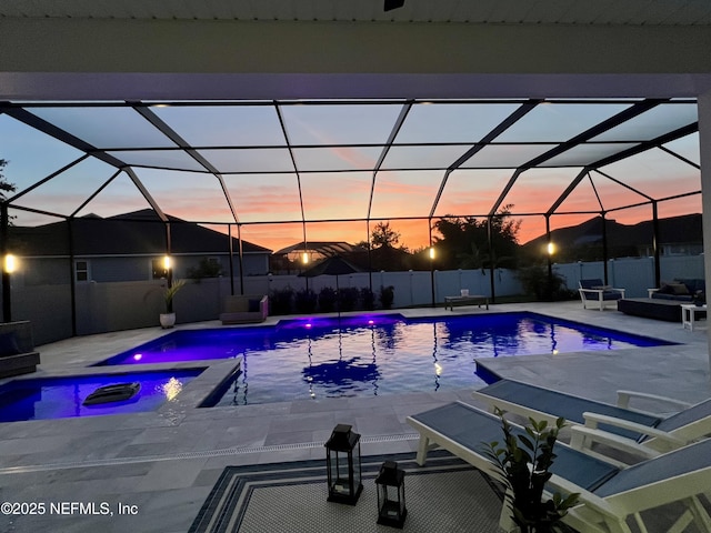 147 Rawlings Dr, Saint Johns, FL 32259 - pool at dusk with a patio, a pool with connected hot tub, and glass enclosure