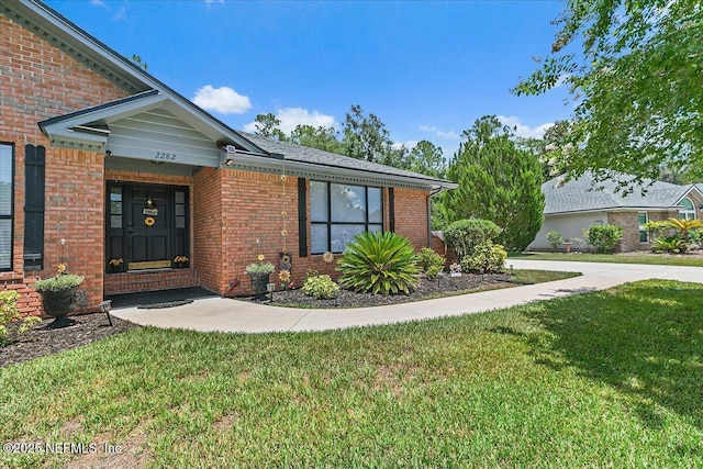 2282 Osceola Forest Ct, Fruit Cove, FL 32259 - doorway to property with a yard and brick siding