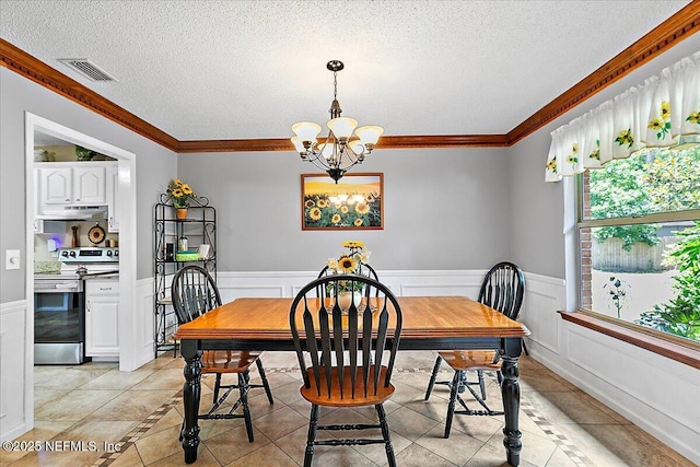 2282 Osceola Forest Ct, Fruit Cove, FL 32259 - dining space with a chandelier, light tile patterned floors, a textured ceiling, wainscoting, and ornamental molding