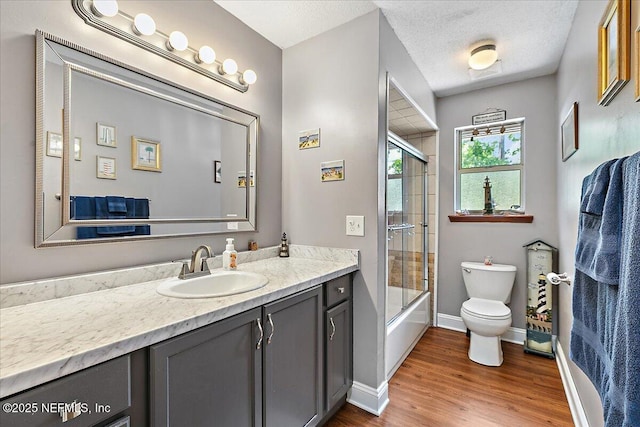 2282 Osceola Forest Ct, Fruit Cove, FL 32259 - bathroom featuring vanity, wood finished floors, bath / shower combo with glass door, and a textured ceiling