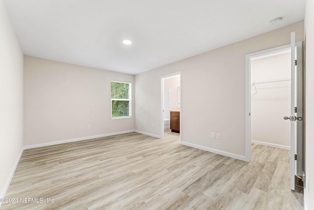 2626 Sandra Ln, Jacksonville, FL 32208 - unfurnished bedroom featuring light wood finished floors, a walk in closet, connected bathroom, and a closet