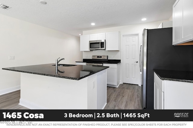 1001 Aiken St, Saint Augustine, FL 32084 - kitchen featuring stainless steel appliances, wood finished floors, recessed lighting, white cabinetry, and a textured ceiling