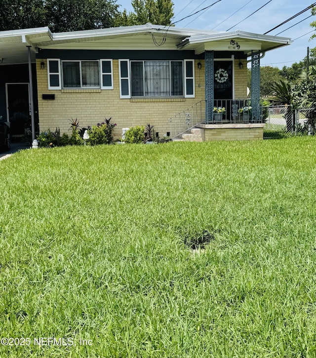 2529 W 28th St, Jacksonville, FL 32209 - view of front of home with brick siding, a front yard, and a carport