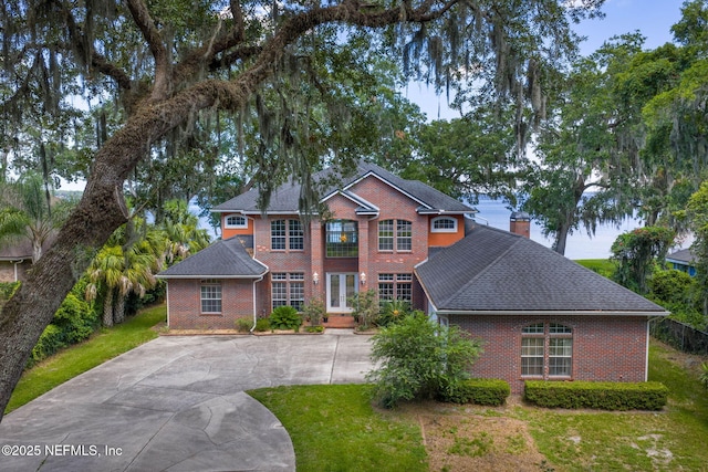3305 US Highway 17, Fleming Island, FL 32003 - view of front of property with brick siding, concrete driveway, a chimney, and a shingled roof