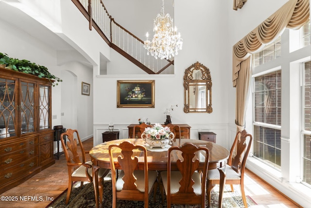 3305 US Highway 17, Fleming Island, FL 32003 - dining area with a high ceiling, light wood-style floors, arched walkways, a chandelier, and a wainscoted wall
