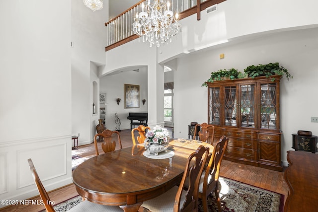 3305 US Highway 17, Fleming Island, FL 32003 - dining area with arched walkways, wood finished floors, a chandelier, and a towering ceiling
