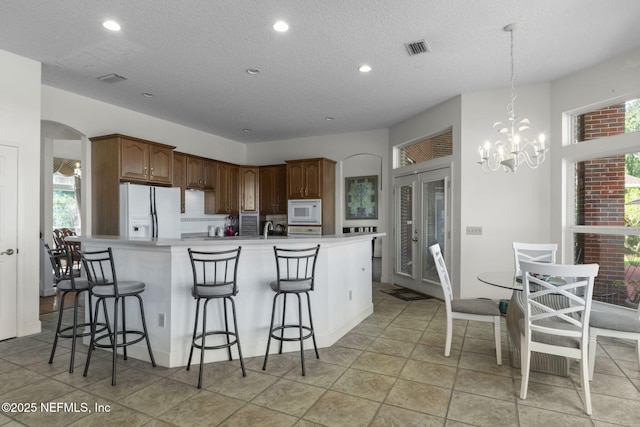 3305 US Highway 17, Fleming Island, FL 32003 - kitchen featuring white appliances, a breakfast bar, a textured ceiling, light countertops, and recessed lighting