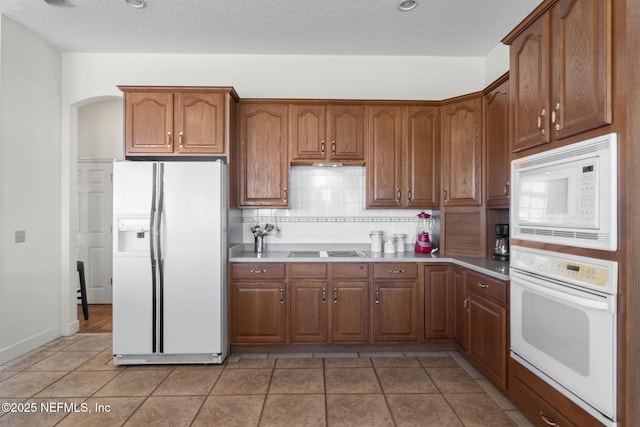 3305 US Highway 17, Fleming Island, FL 32003 - kitchen with white appliances, decorative backsplash, arched walkways, light tile patterned flooring, and a textured ceiling