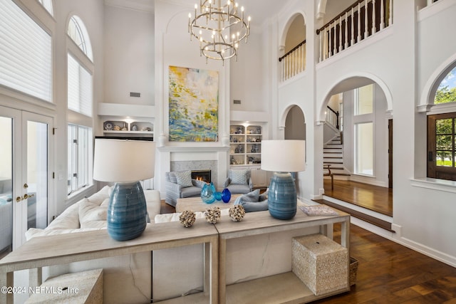 105 Teal Nest Ct, Ponte Vedra Beach, FL 32082 - living room with a towering ceiling, dark wood finished floors, a lit fireplace, stairs, and built in shelves