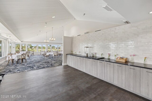 105 Teal Nest Ct, Ponte Vedra Beach, FL 32082 - bar area with high vaulted ceiling, dark wood-style floors, a chandelier, and hanging light fixtures