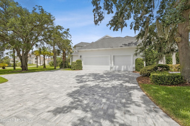 105 Teal Nest Ct, Ponte Vedra Beach, FL 32082 - view of front of house featuring decorative driveway, an attached garage, stucco siding, roof with shingles, and a front yard