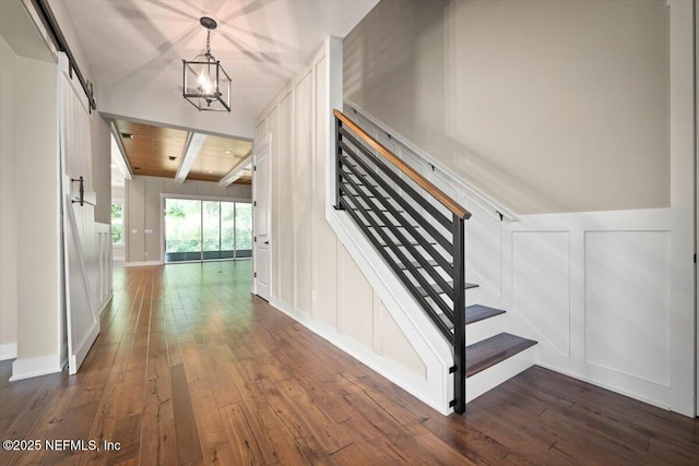 305 Seahill Dr, Saint Augustine, FL 32092 - hallway featuring a decorative wall, dark wood finished floors, stairs, beam ceiling, and a wainscoted wall