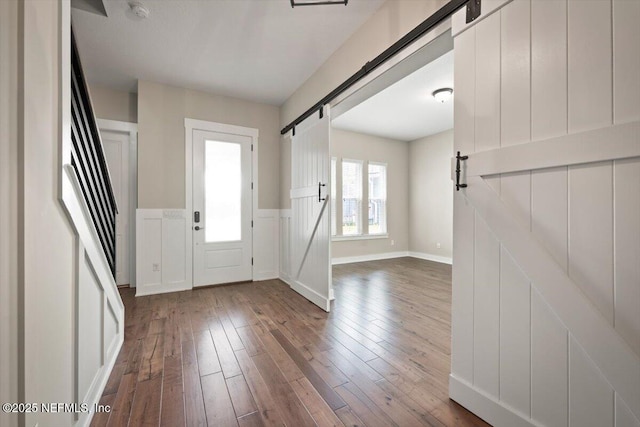 305 Seahill Dr, Saint Augustine, FL 32092 - entrance foyer with a barn door, dark wood-type flooring, and wainscoting