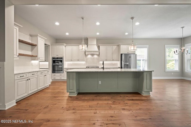 305 Seahill Dr, Saint Augustine, FL 32092 - kitchen with stainless steel appliances, custom exhaust hood, open shelves, white cabinetry, and light wood finished floors