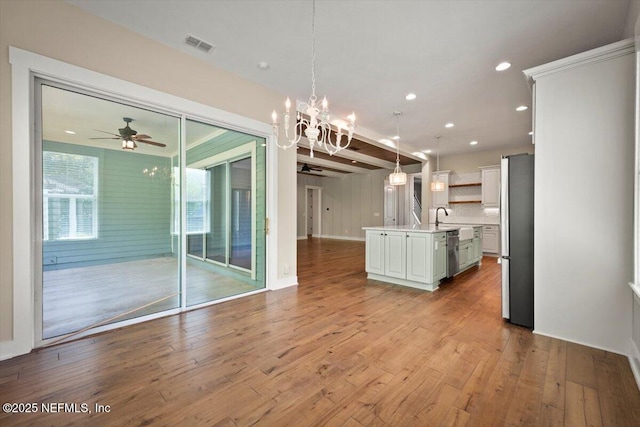 305 Seahill Dr, Saint Augustine, FL 32092 - kitchen with stainless steel appliances, open shelves, light countertops, light wood finished floors, and white cabinetry