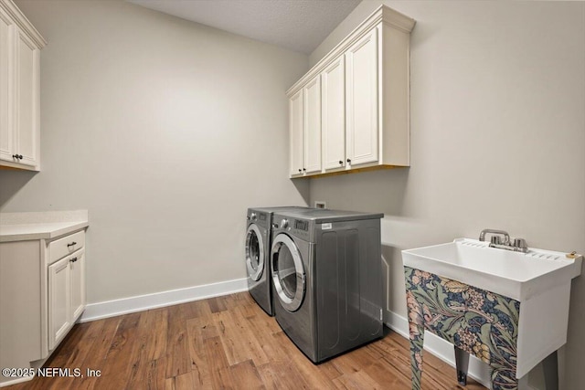 305 Seahill Dr, Saint Augustine, FL 32092 - laundry area with cabinet space, light wood finished floors, and washing machine and clothes dryer