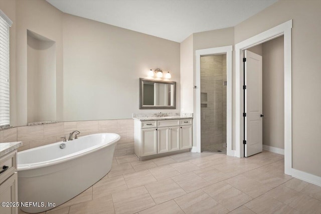 305 Seahill Dr, Saint Augustine, FL 32092 - full bathroom featuring vanity, a freestanding tub, a stall shower, and tile walls