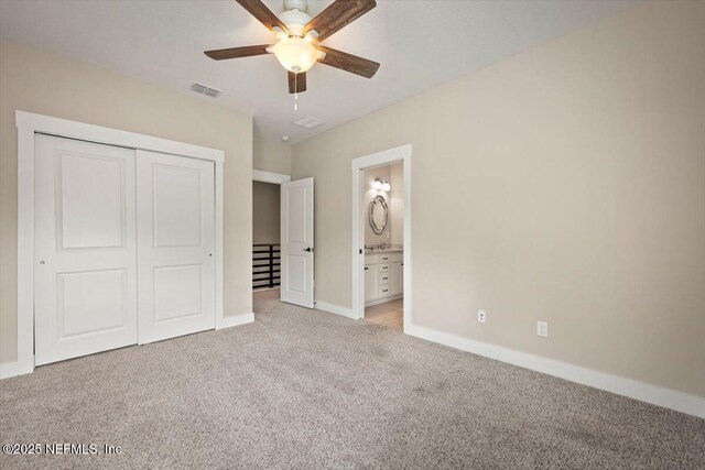 305 Seahill Dr, Saint Augustine, FL 32092 - unfurnished bedroom featuring light carpet, a closet, a ceiling fan, and connected bathroom