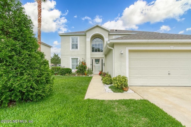 76146 Long Leaf Loop, Yulee, FL 32097 - traditional-style house with stucco siding, driveway, a front yard, a garage, and a shingled roof